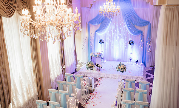 wedding ceremony setup with white and blue decor featuring floral arrangements and candles in an elegant venue perfect for a celebration of love and happiness with seven decorative elements
