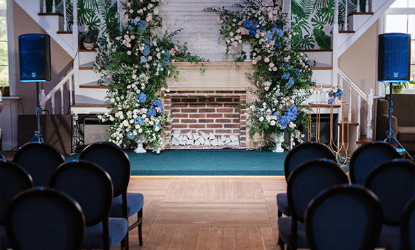 wedding ceremony setup with floral decorations and seating for 5 guests in a beautiful venue