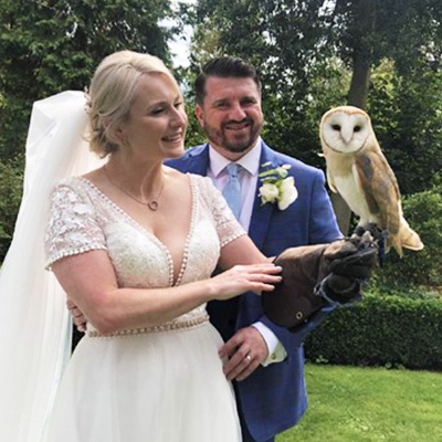 bride holding owl with groom smiling in garden during wedding celebration 11 amazing wedding moments